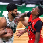 Jayson Tatum plows into Raptors Chris Boucher on a drive to the basket in the 4th qtr.
