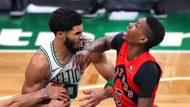 Jayson Tatum plows into Raptors Chris Boucher on a drive to the basket in the 4th qtr.