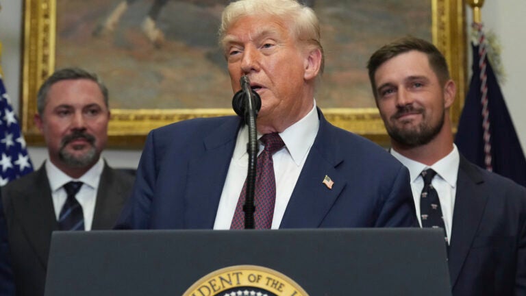 President Donald Trump speaks as Cody Campbell, left, and professional golfer Bryson DeChambeau listen during an event for the signing of an executive order restarting the Presidential Fitness Test in public schools, Thursday, July 31, 2025, in the Roosevelt Room of the White House in Washington.
